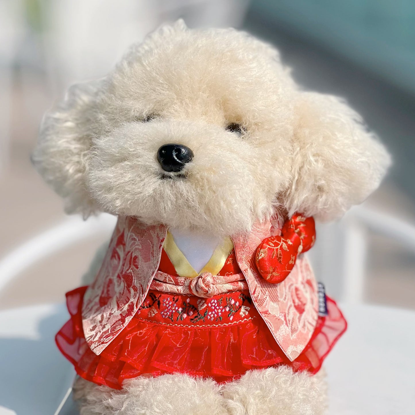 Fluffy cream dog wearing the Shine red floral Hanfu bandana