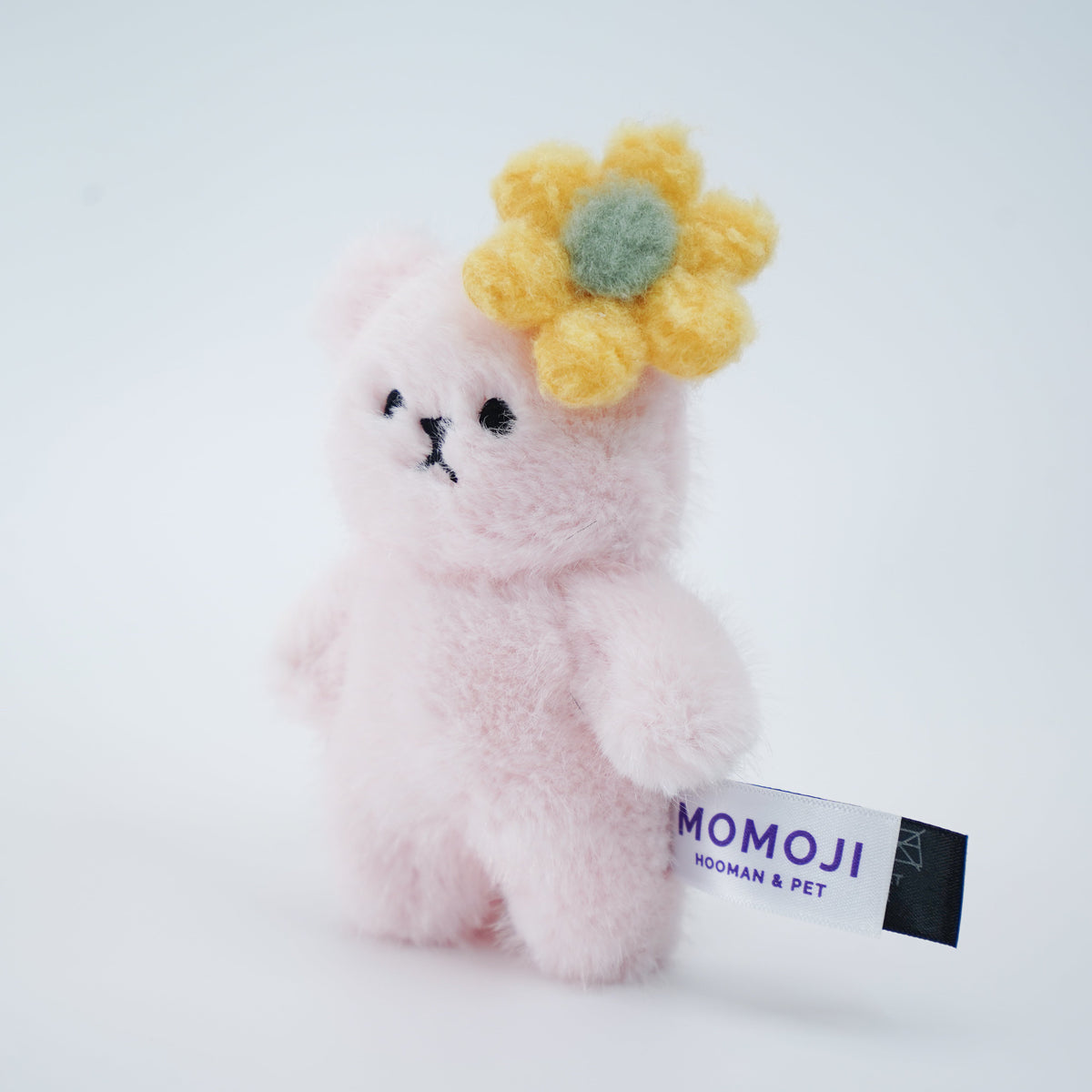 Small pink Momoji Bear plush with yellow flower clip