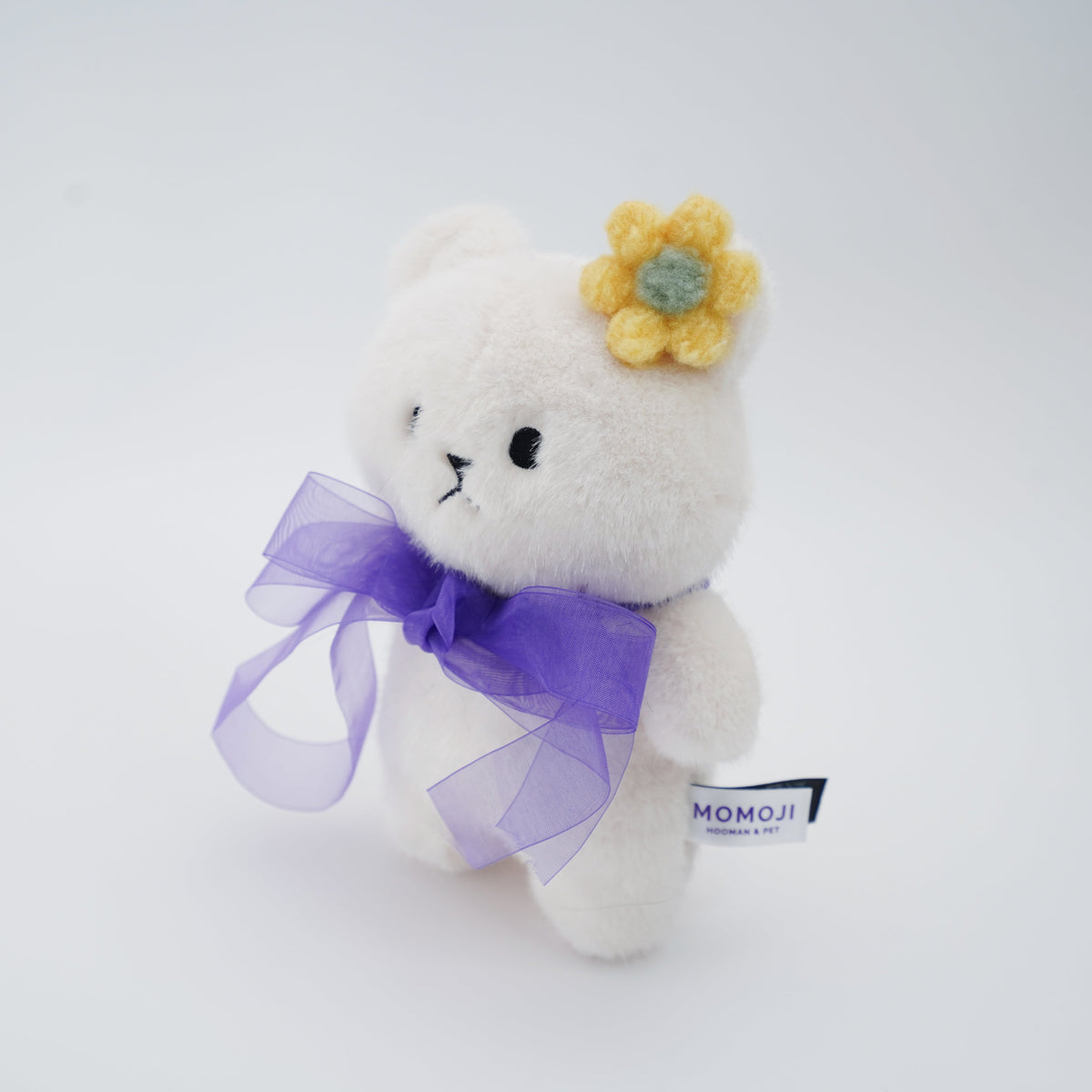 Cream Momoji Bear plush with lilac bow, side view